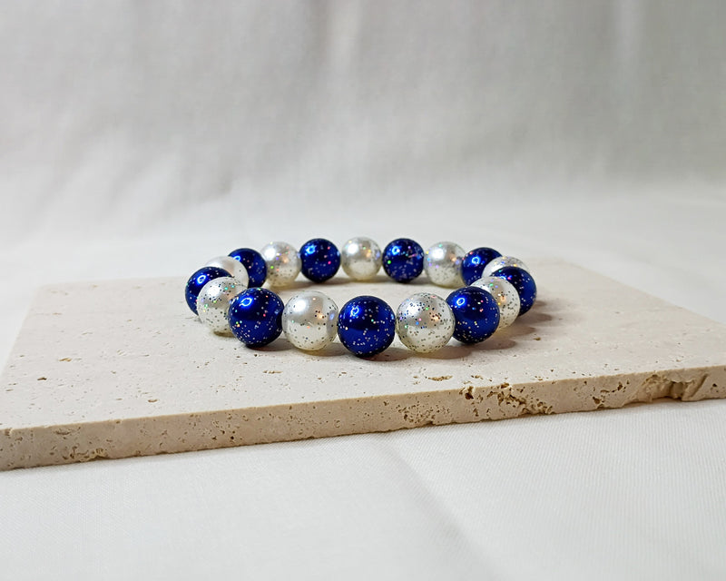 Bracelet with blue and silver beads on a light surface