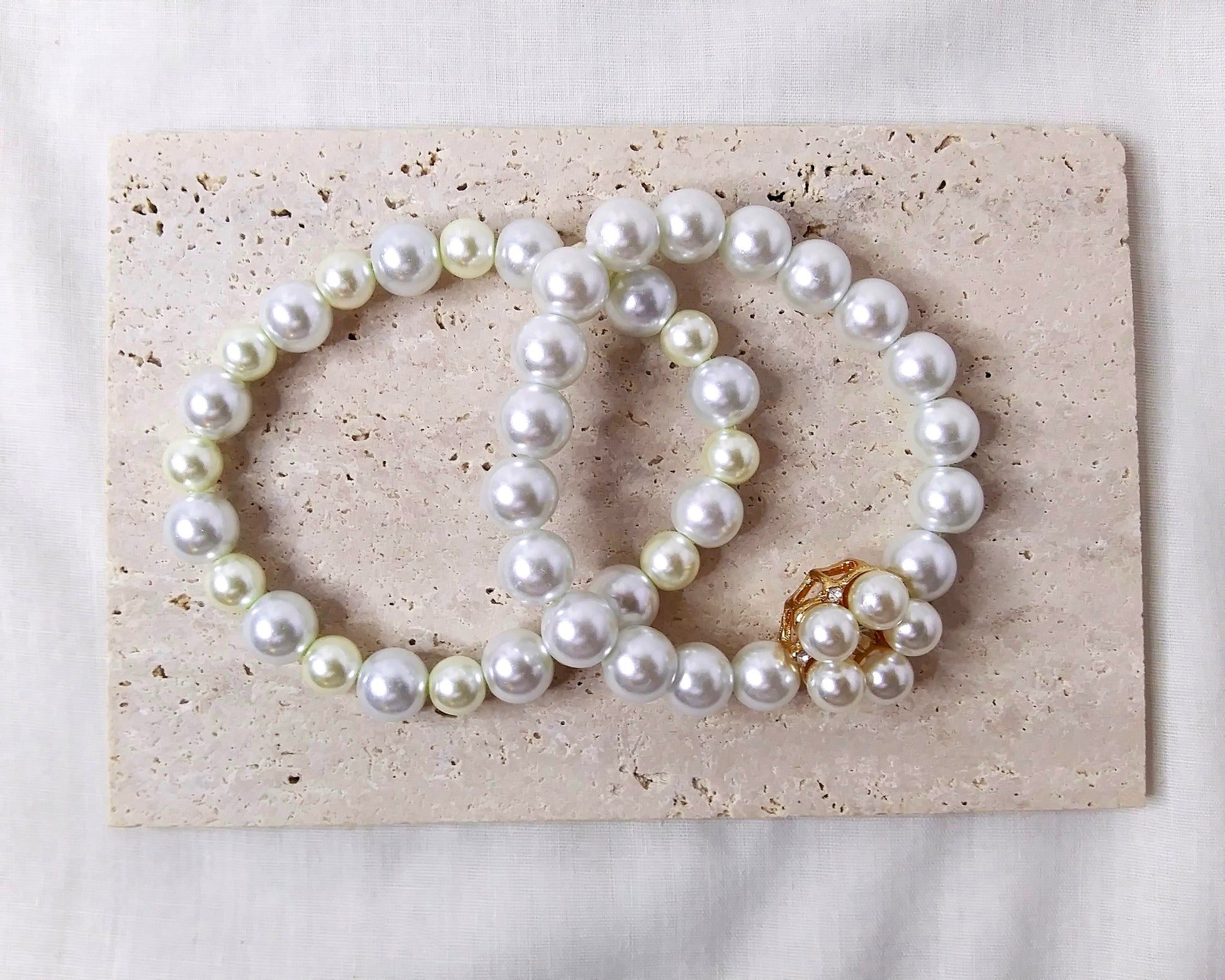 two white and cream pearl bracelet with gold accent