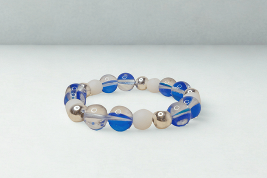 Beaded bracelet with blue, white, and gold beads on a light gray background