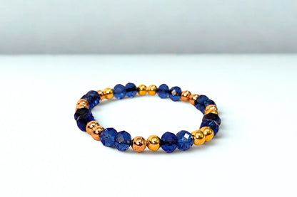 Beaded bracelet with blue and gold beads on a white background
