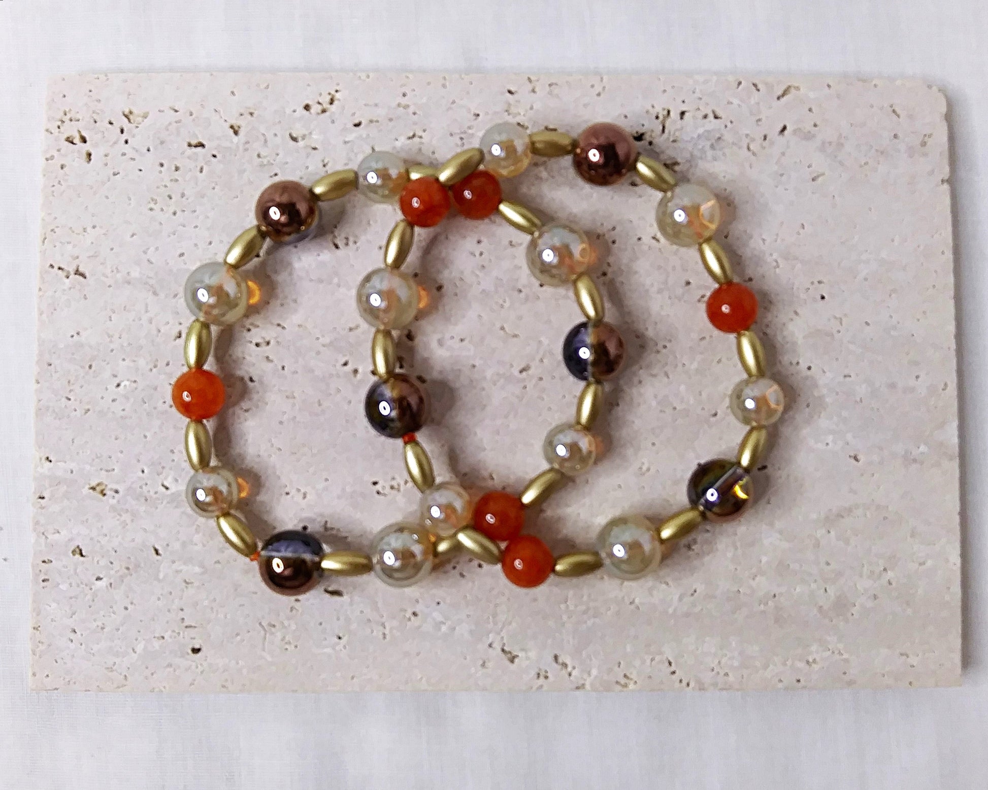 Two stretch stackable bracelets in gold and orange
